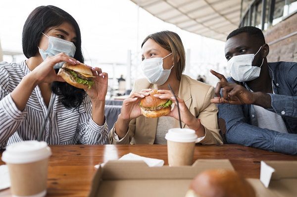 Amigos comiendo comida basura con COVID