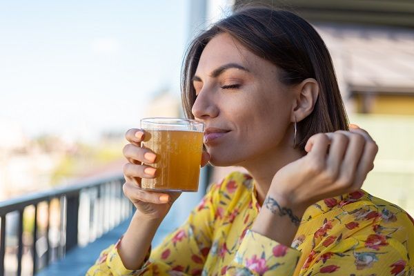 Mujer bebiendo y disfrutando de un vaso de hidromiel
